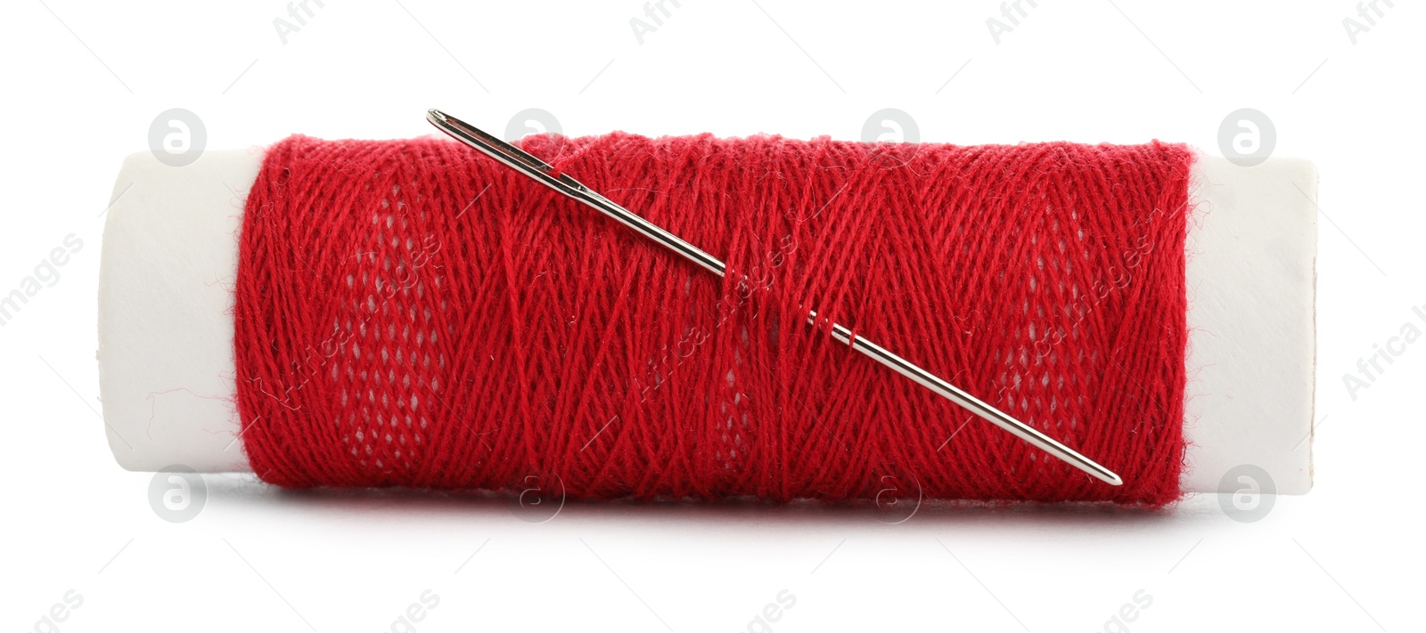 Photo of Spool of red sewing thread with needle isolated on white