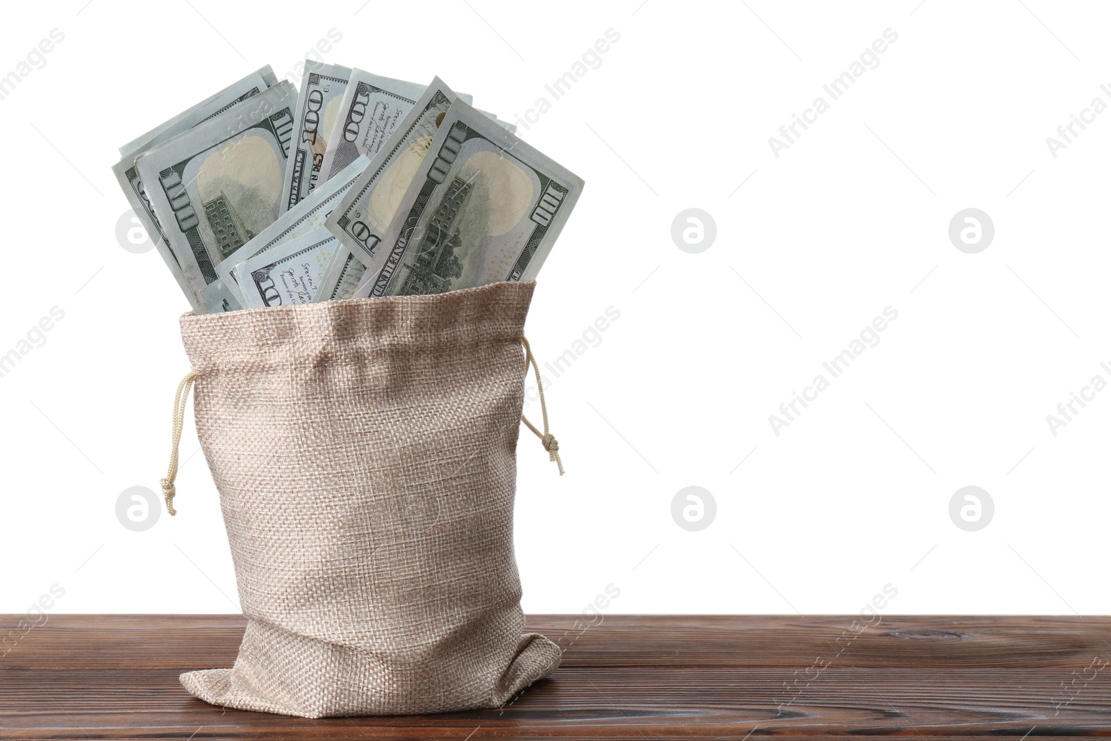 Photo of Dollar banknotes in bag on wooden table against white background, space for text