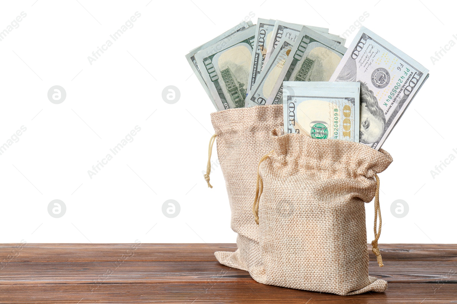 Photo of Dollar banknotes in bags on wooden table against white background, space for text