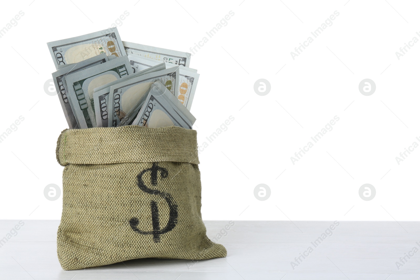 Photo of Dollar banknotes in bag on table against white background, space for text