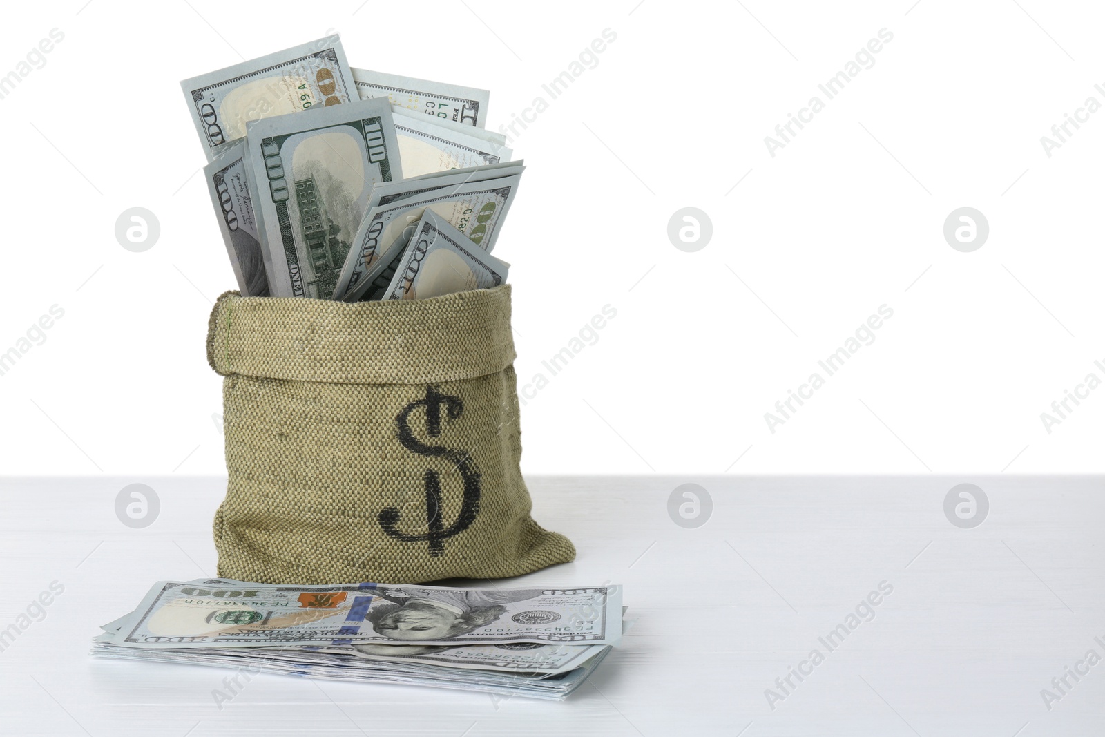 Photo of Dollar banknotes in bag on table against white background, space for text