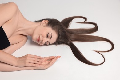 Photo of Beautiful young woman with hair in shape of hearts on white background