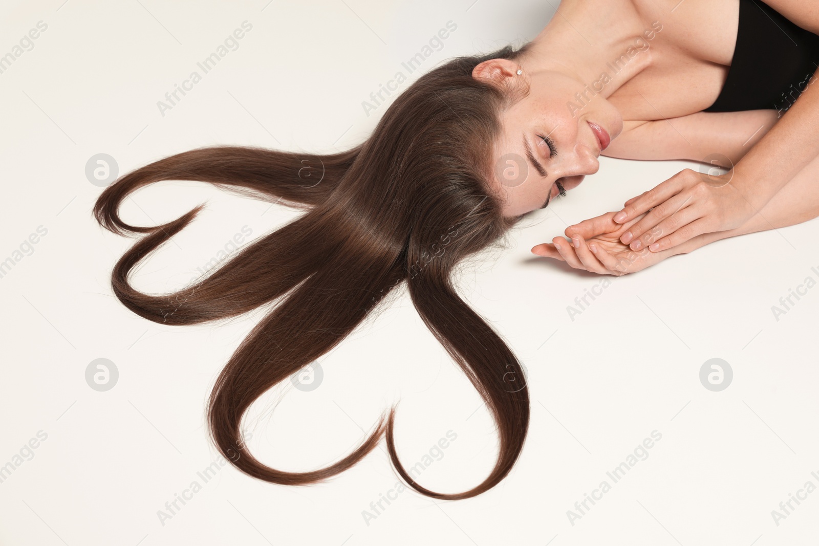 Photo of Beautiful young woman with hair in shape of hearts on white background