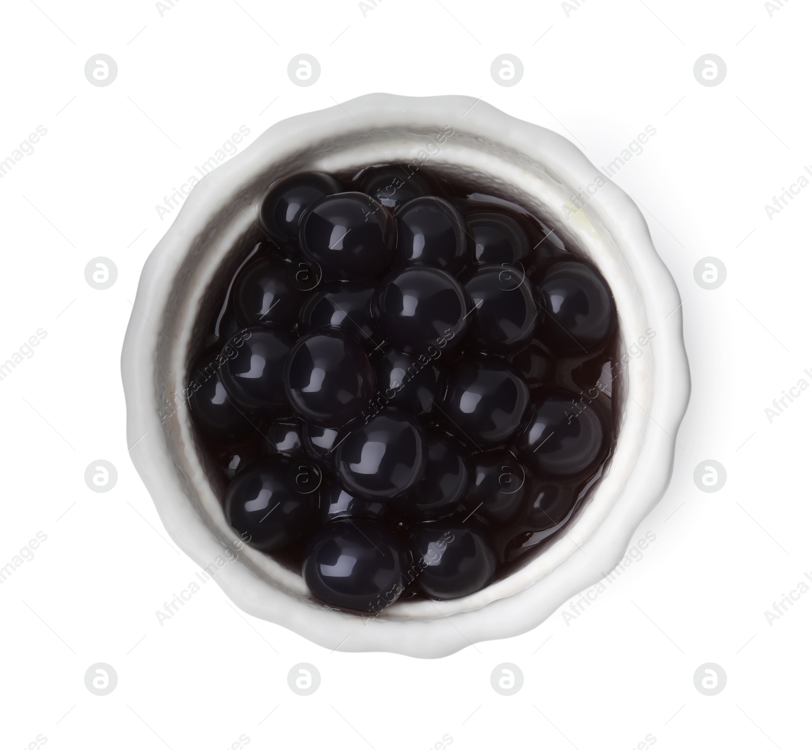 Photo of Dark tapioca pearls in bowl isolated on white, top view