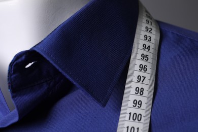 Mannequin with blue shirt and measuring tape, closeup