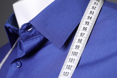 Mannequin with blue shirt and measuring tape, closeup