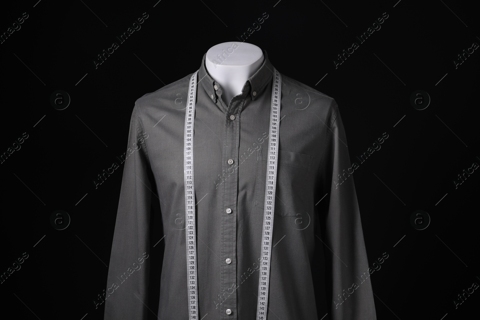 Photo of Male mannequin with grey shirt and measuring tape on black background