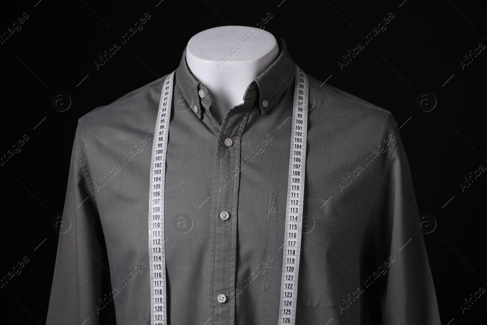 Photo of Male mannequin with grey shirt and measuring tape on black background