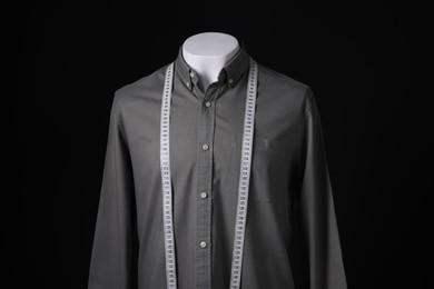 Photo of Male mannequin with grey shirt and measuring tape on black background