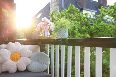 Photo of Different plants on railings and chair at cozy balcony outdoors