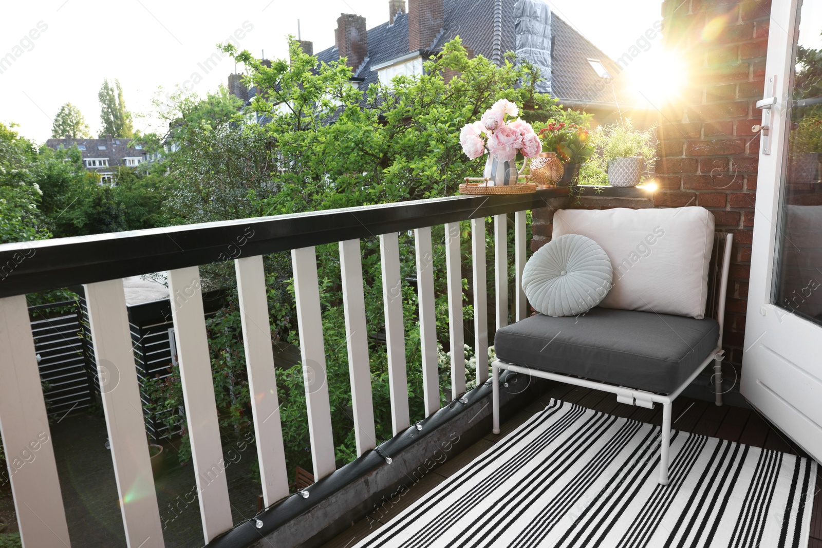 Photo of Different plants on railings and chair at cozy balcony outdoors