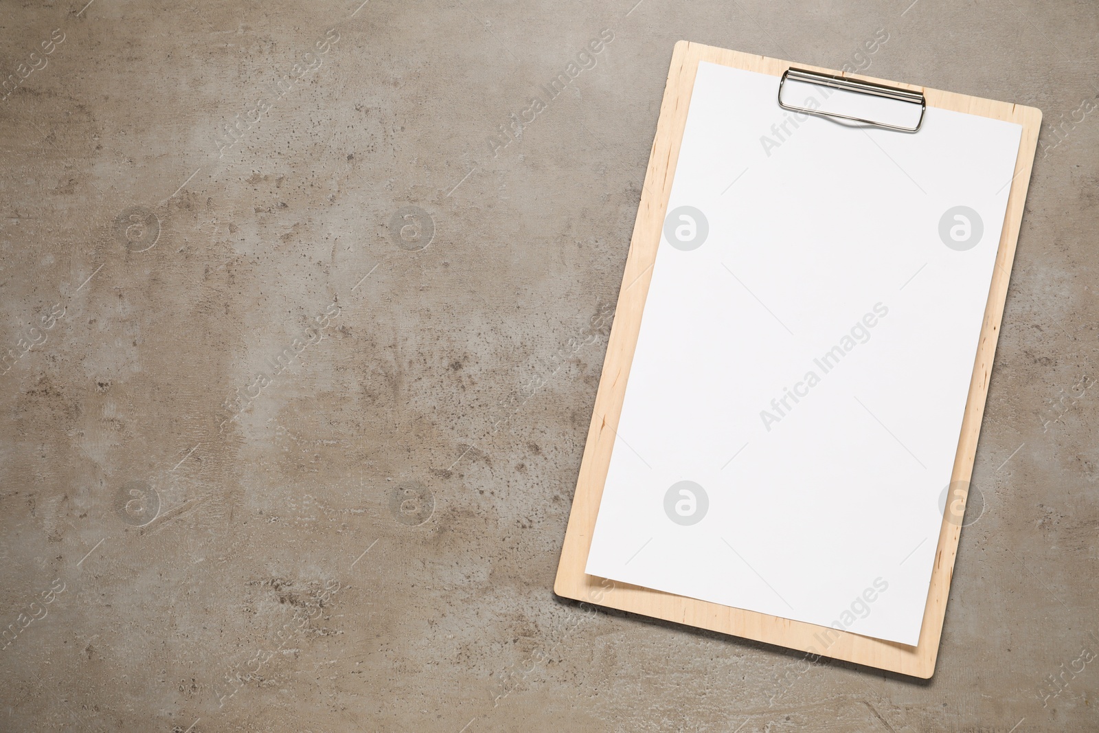 Photo of Clipboard with empty paper on grey textured table, top view. Mockup for design