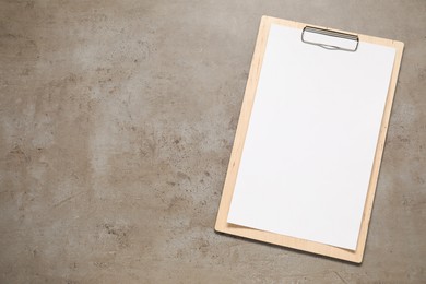 Photo of Clipboard with empty paper on grey textured table, top view. Mockup for design