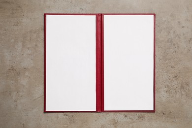 Hardcover notebook with blank sheets on grey textured table, top view. Mockup for design