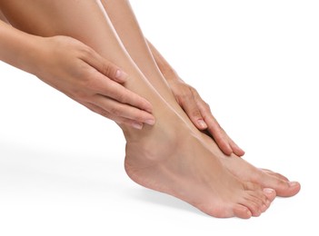 Photo of Woman touching her smooth feet on white background, closeup