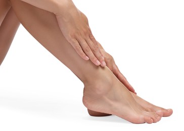 Photo of Woman touching her smooth feet on white background, closeup