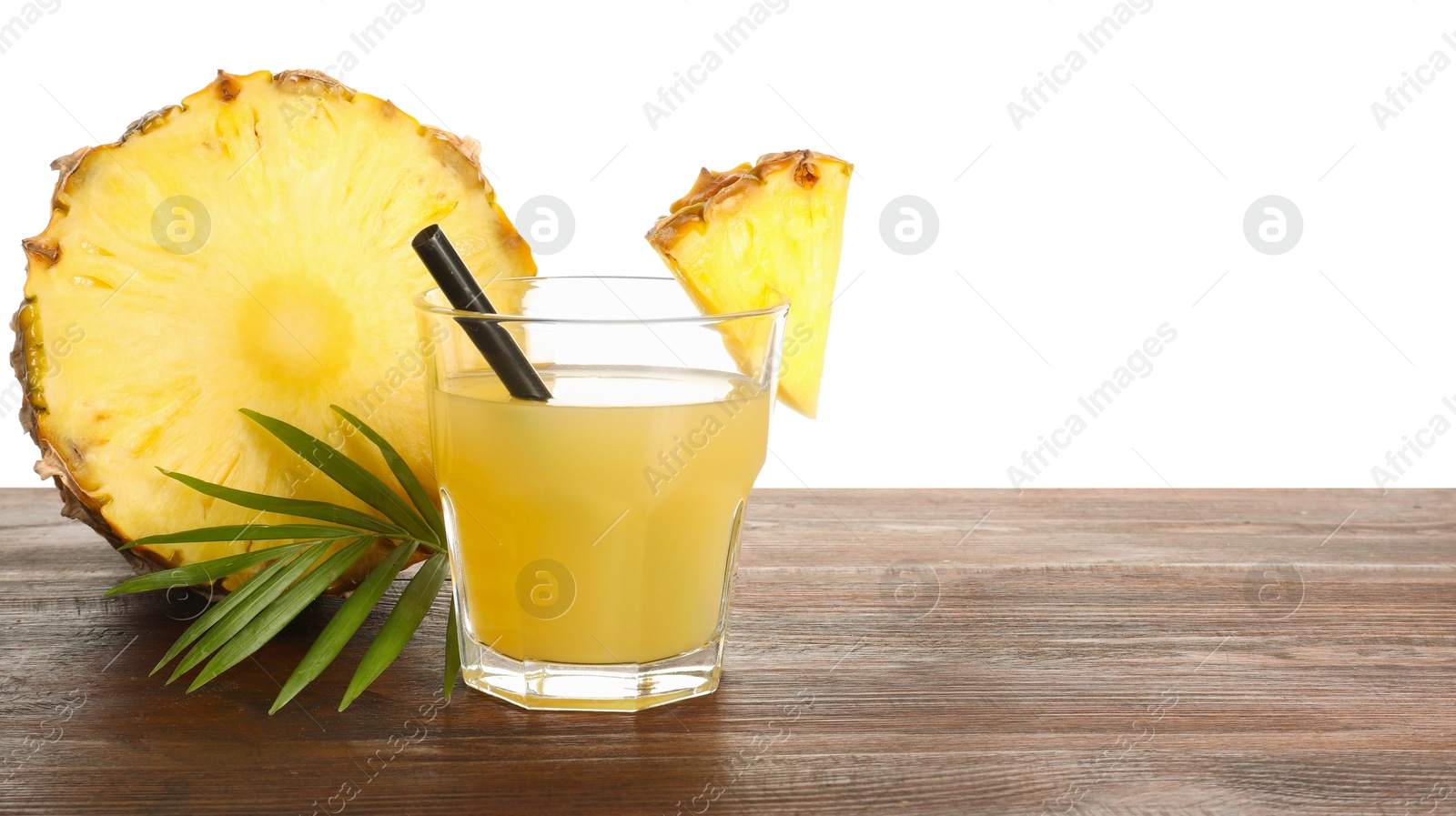 Photo of Glass with pineapple juice and pieces of fresh fruit on wooden table against white background