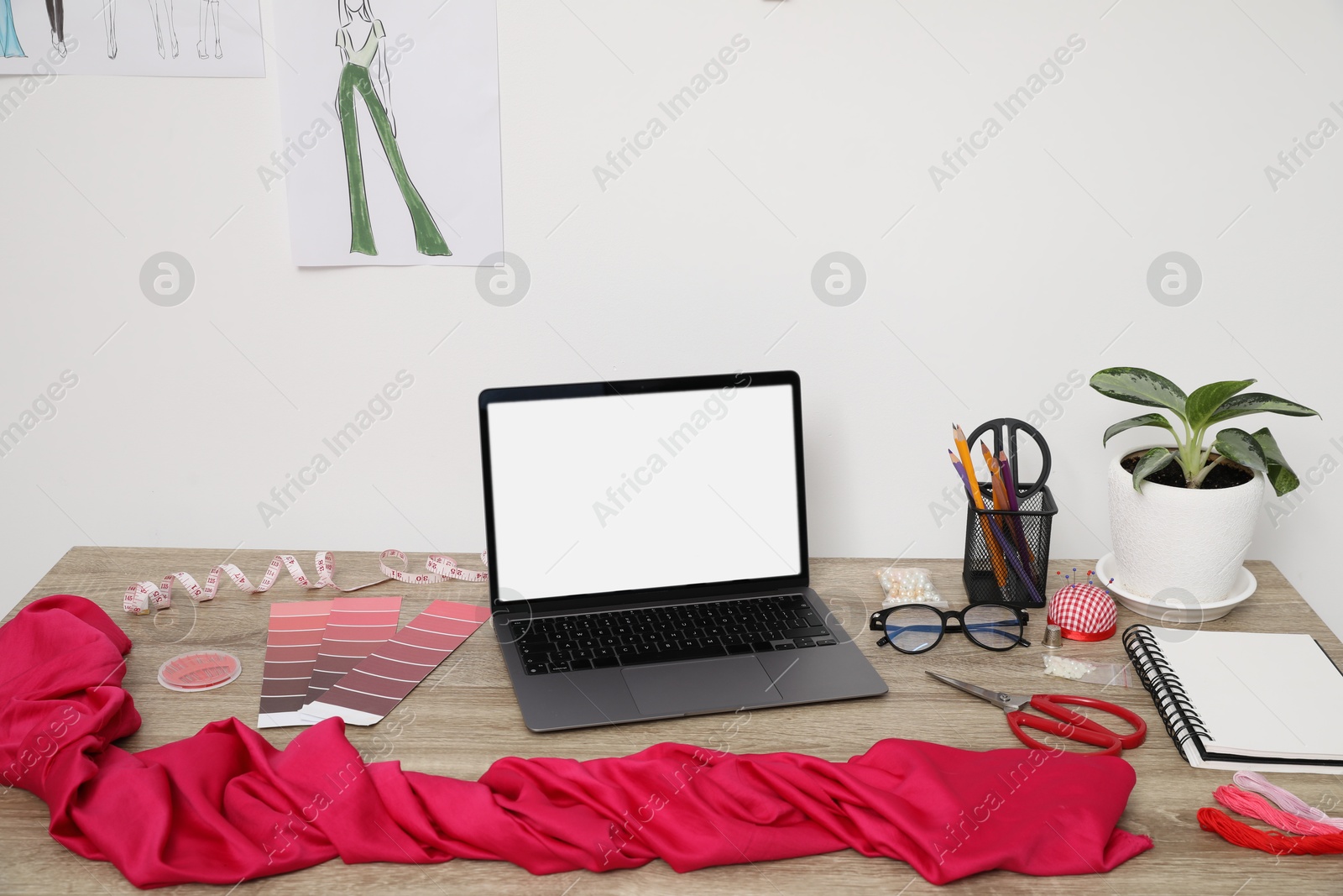 Photo of Laptop and different designer`s supplies on wooden table in workshop