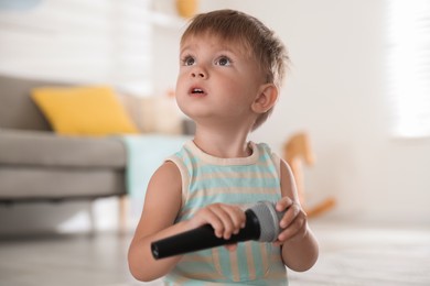 Photo of Cute little baby with microphone at home