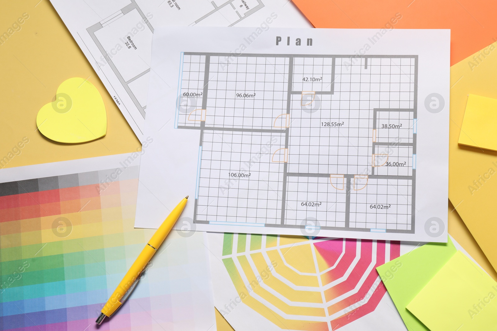 Photo of Designer's workplace with house plans, color palettes and stationery on yellow table, flat lay