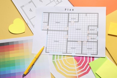 Photo of Designer's workplace with house plans, color palettes and stationery on yellow table, flat lay