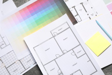 Designer's workplace with house plans, color palettes and stationery on table, flat lay