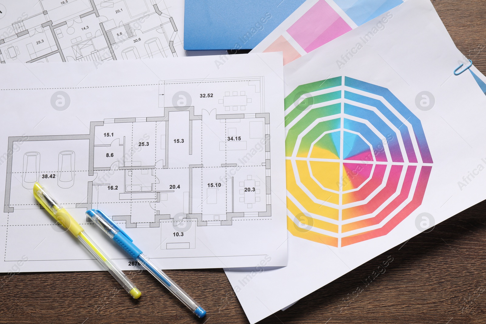 Photo of Designer's workplace with house plans, color palettes and stationery on wooden table, flat lay