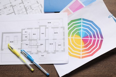 Photo of Designer's workplace with house plans, color palettes and stationery on wooden table, flat lay