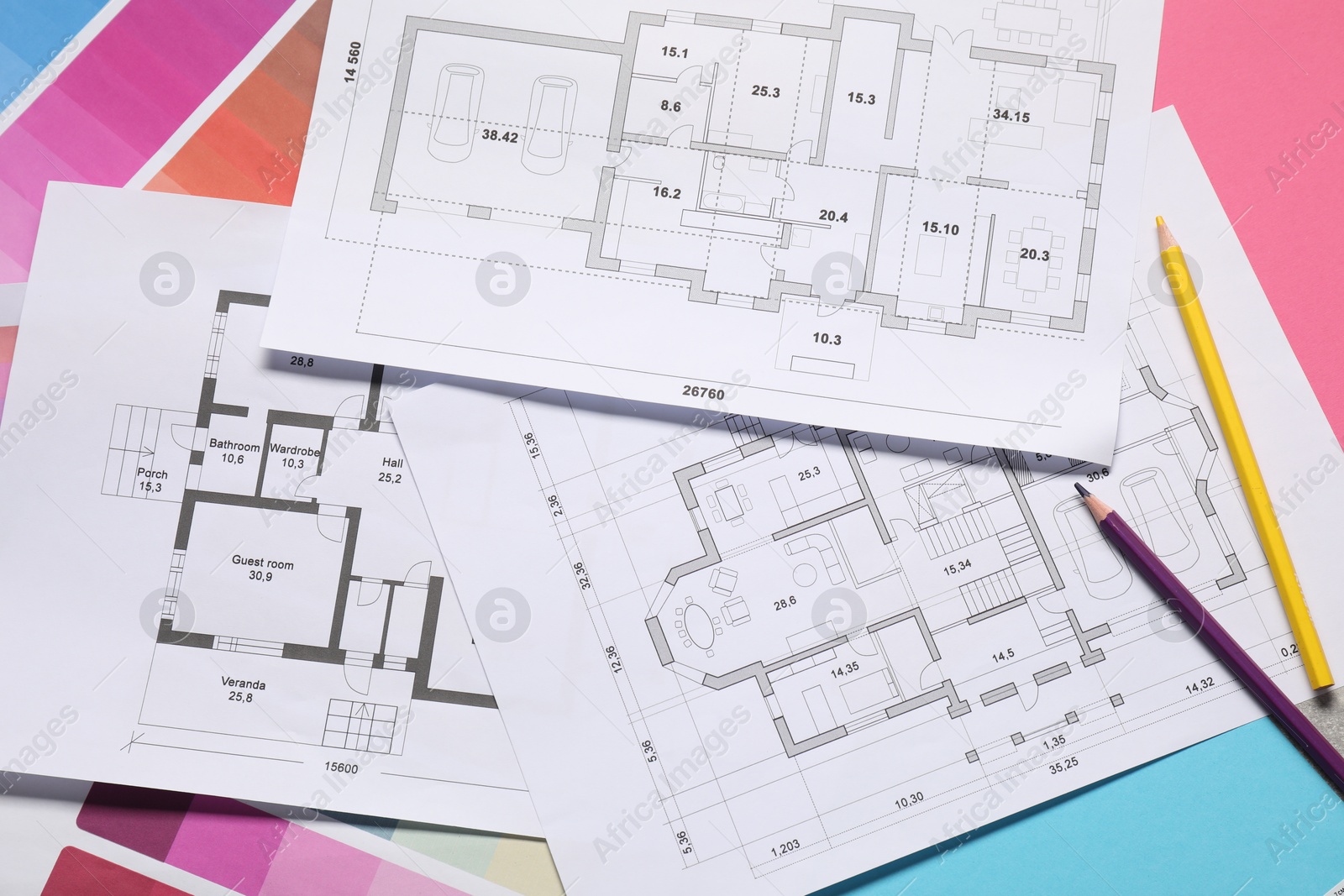 Photo of Designer's workplace with house plans, color palettes and pencils on table, top view