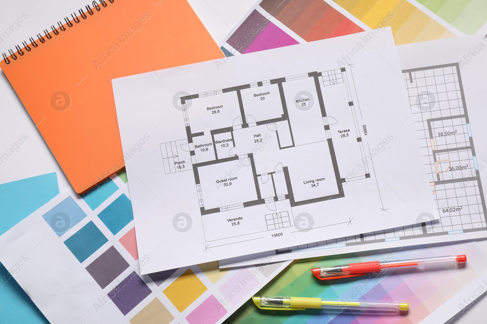 Photo of Designer's workplace with house plans, color palettes and pens on table, top view