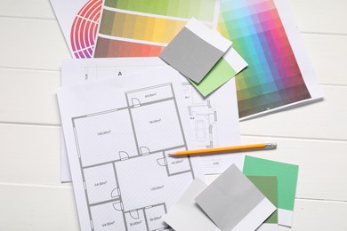 Designer's workplace with different color palettes, floor plans and pencil on white wooden table, flat lay