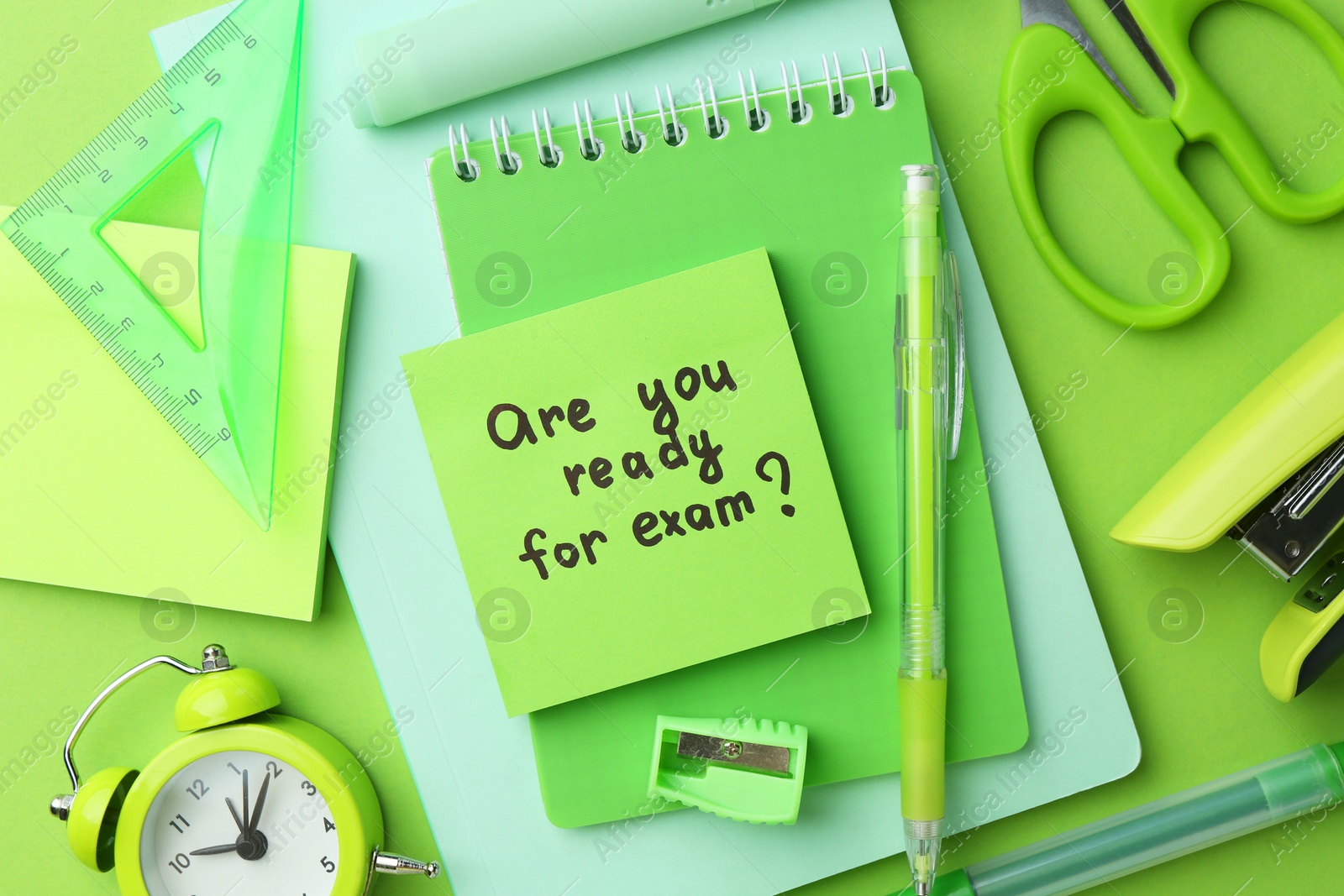 Photo of Paper note with question Are You Ready For Exam and stationery on green background, flat lay