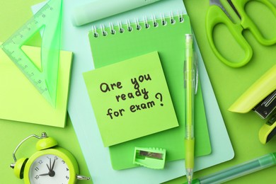 Paper note with question Are You Ready For Exam and stationery on green background, flat lay