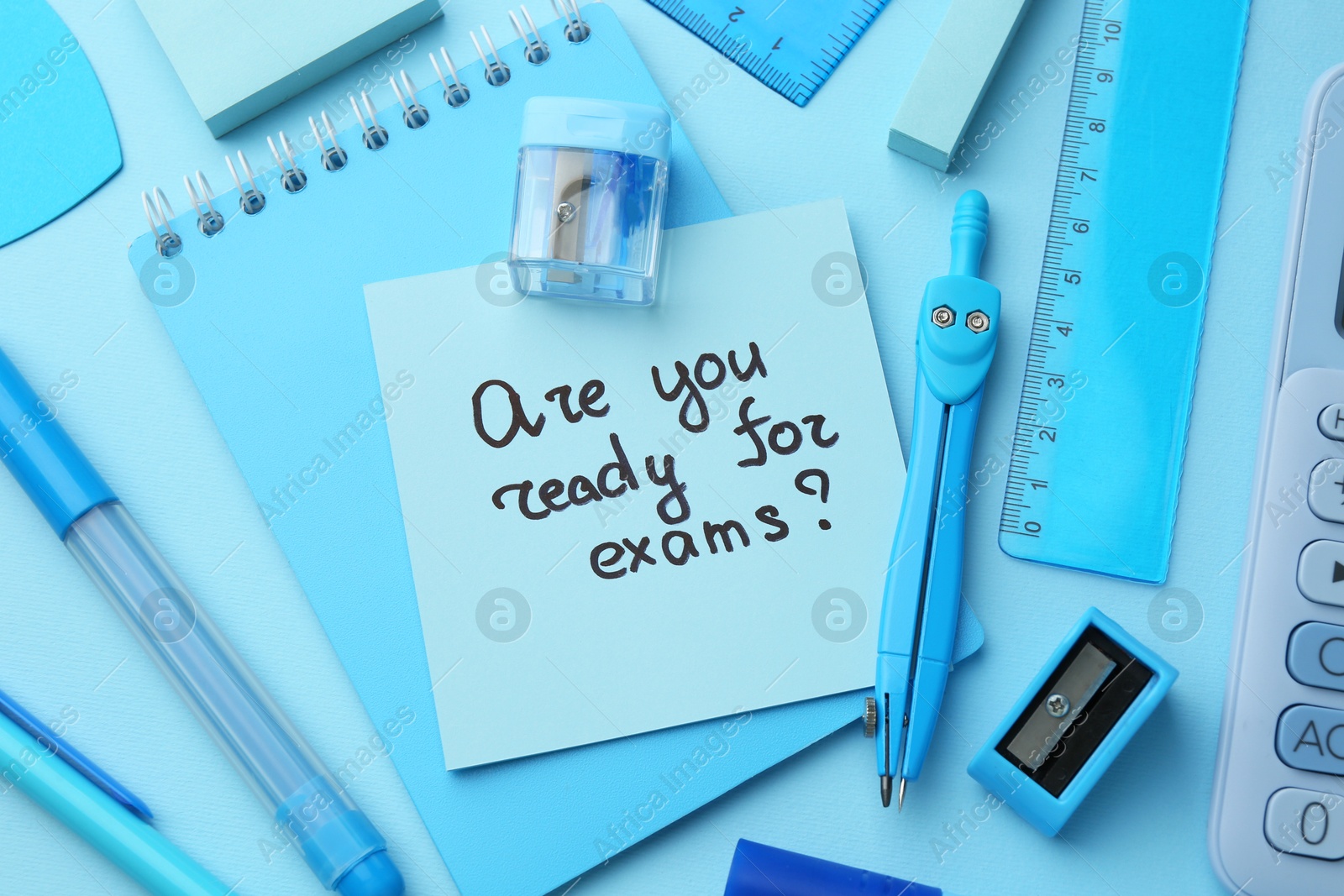 Photo of Paper note with question Are You Ready For Exam and stationery on light blue background, flat lay