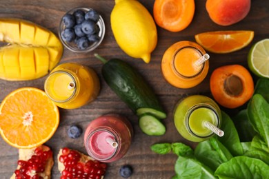 Glass bottles of tasty smoothies and different products on wooden table, flat lay