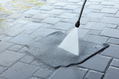 Photo of Washing car mat with high pressure water jet outdoors, closeup