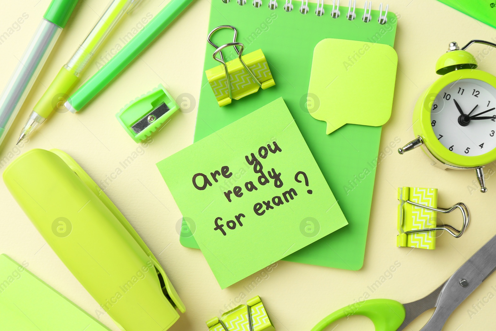 Photo of Paper note with question Are You Ready For Exam and stationery on pale yellow background, flat lay