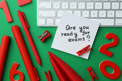 Photo of Paper note with question Are You Ready For Exam and stationery on green background, flat lay