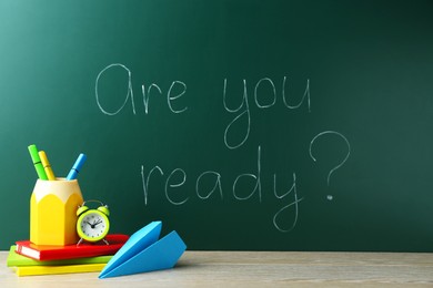 Photo of Chalkboard with question Are You Ready and stationery on wooden desk