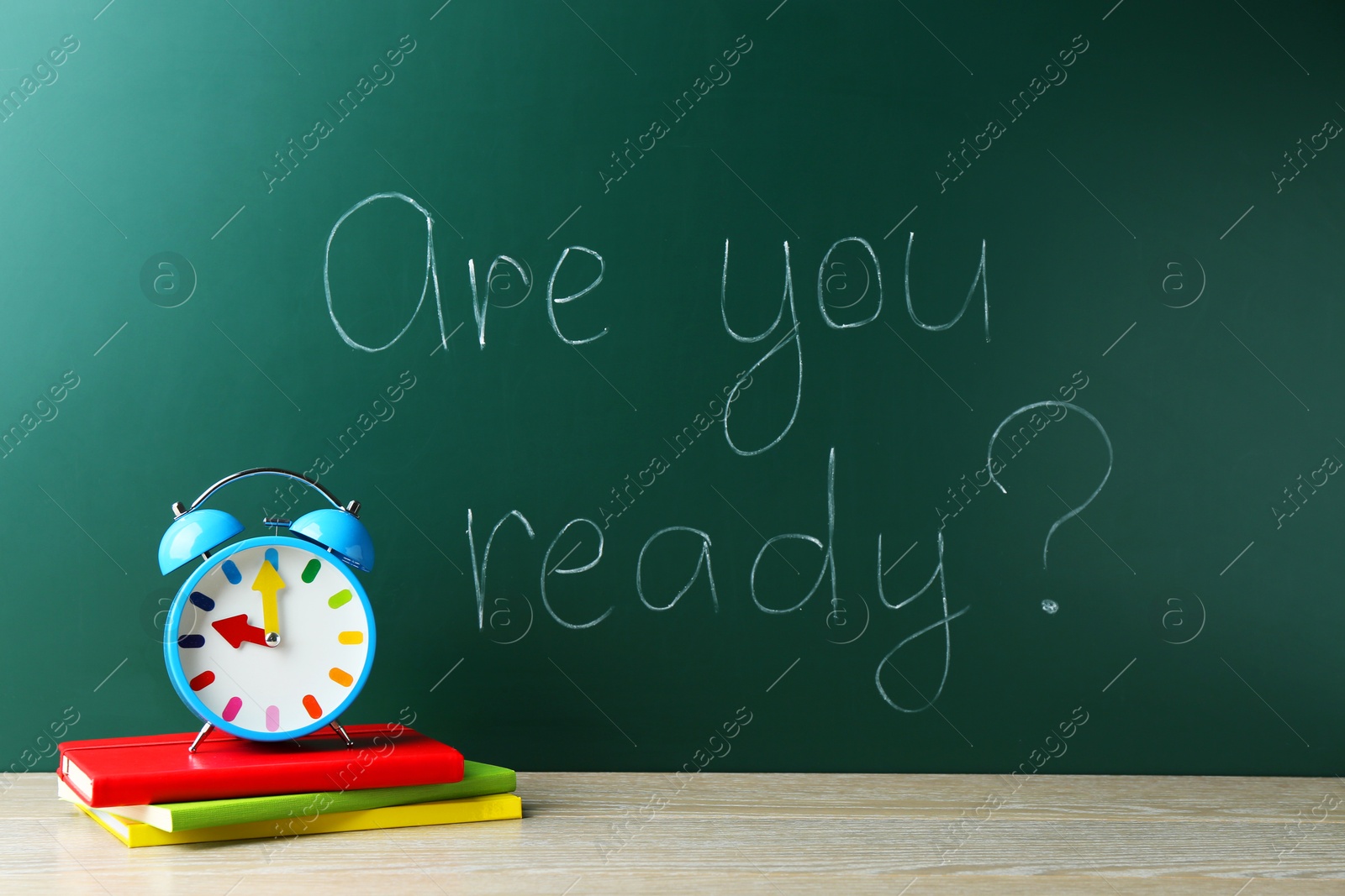 Photo of Chalkboard with question Are You Ready and alarm clock, books on wooden desk