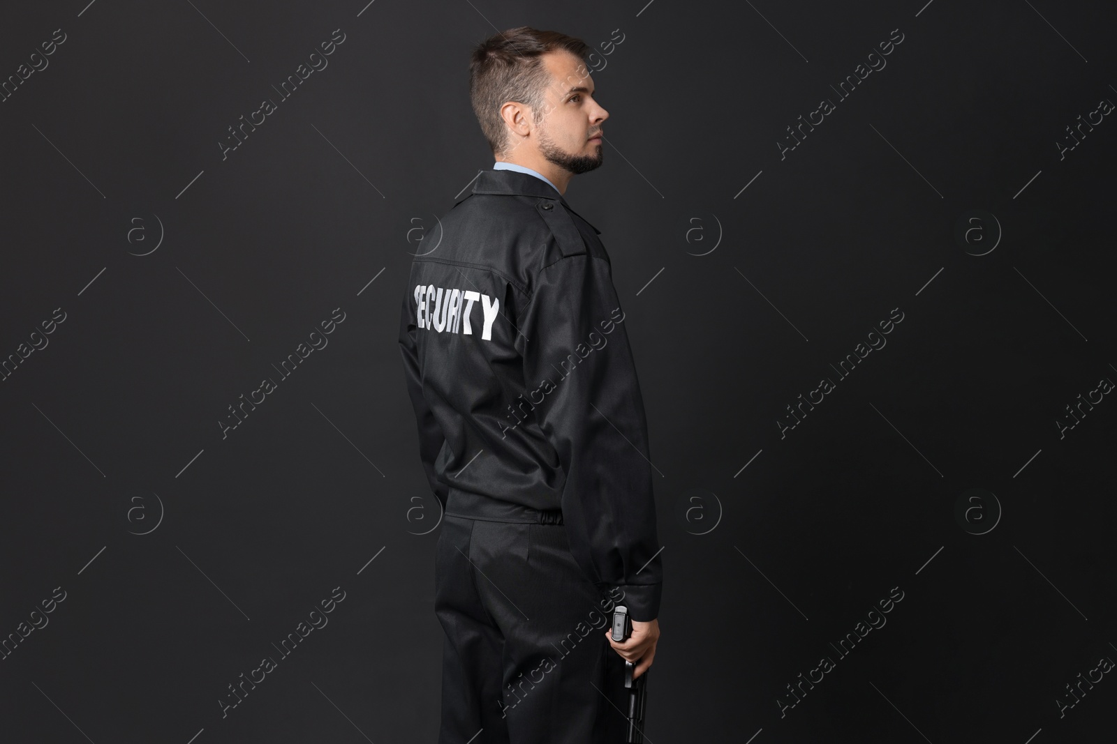 Photo of Security guard in uniform with gun on black background