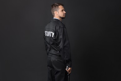 Photo of Security guard in uniform with gun on black background