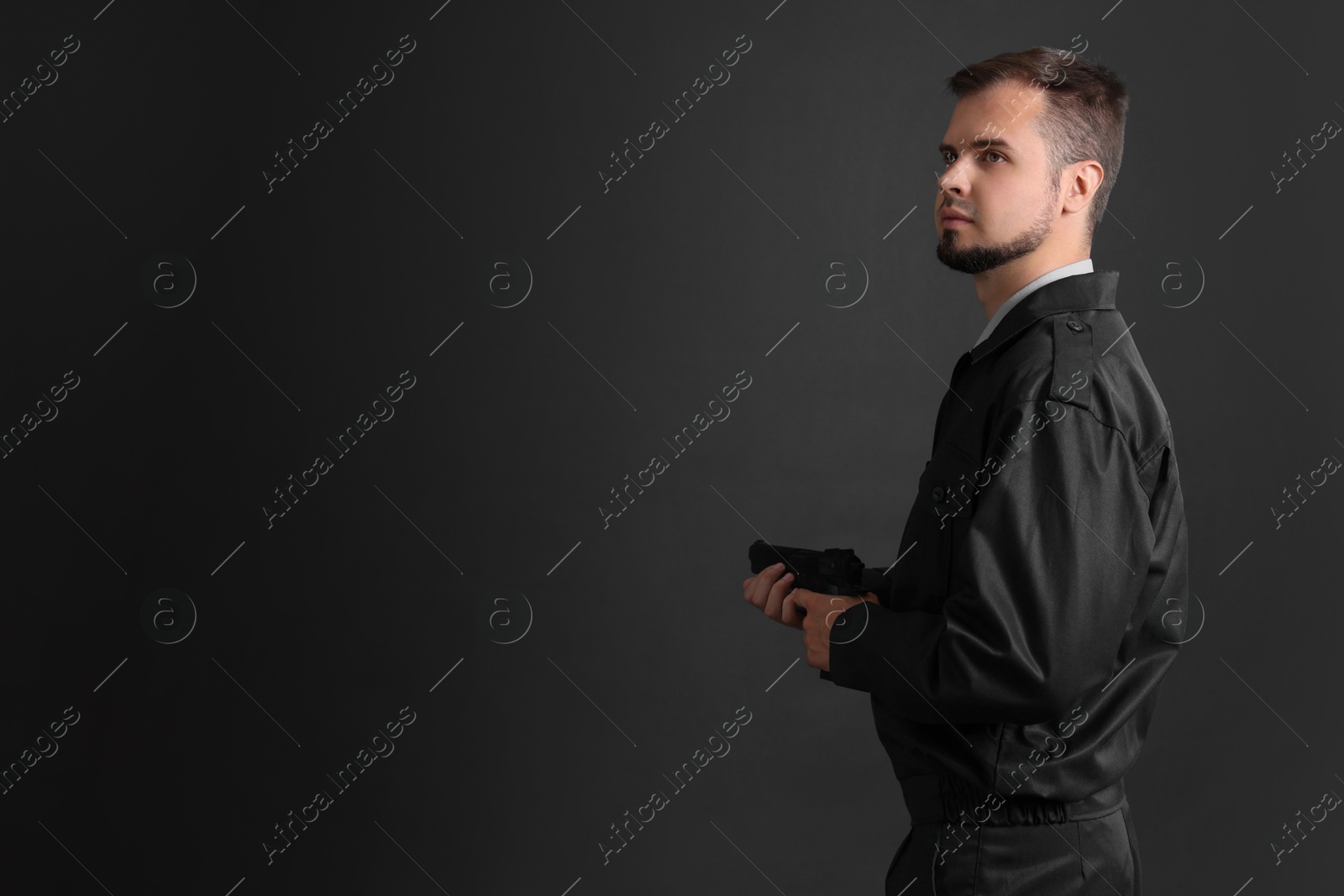 Photo of Security guard in uniform with gun on black background, space for text