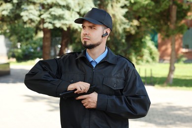 Security guard in uniform with gun outdoors