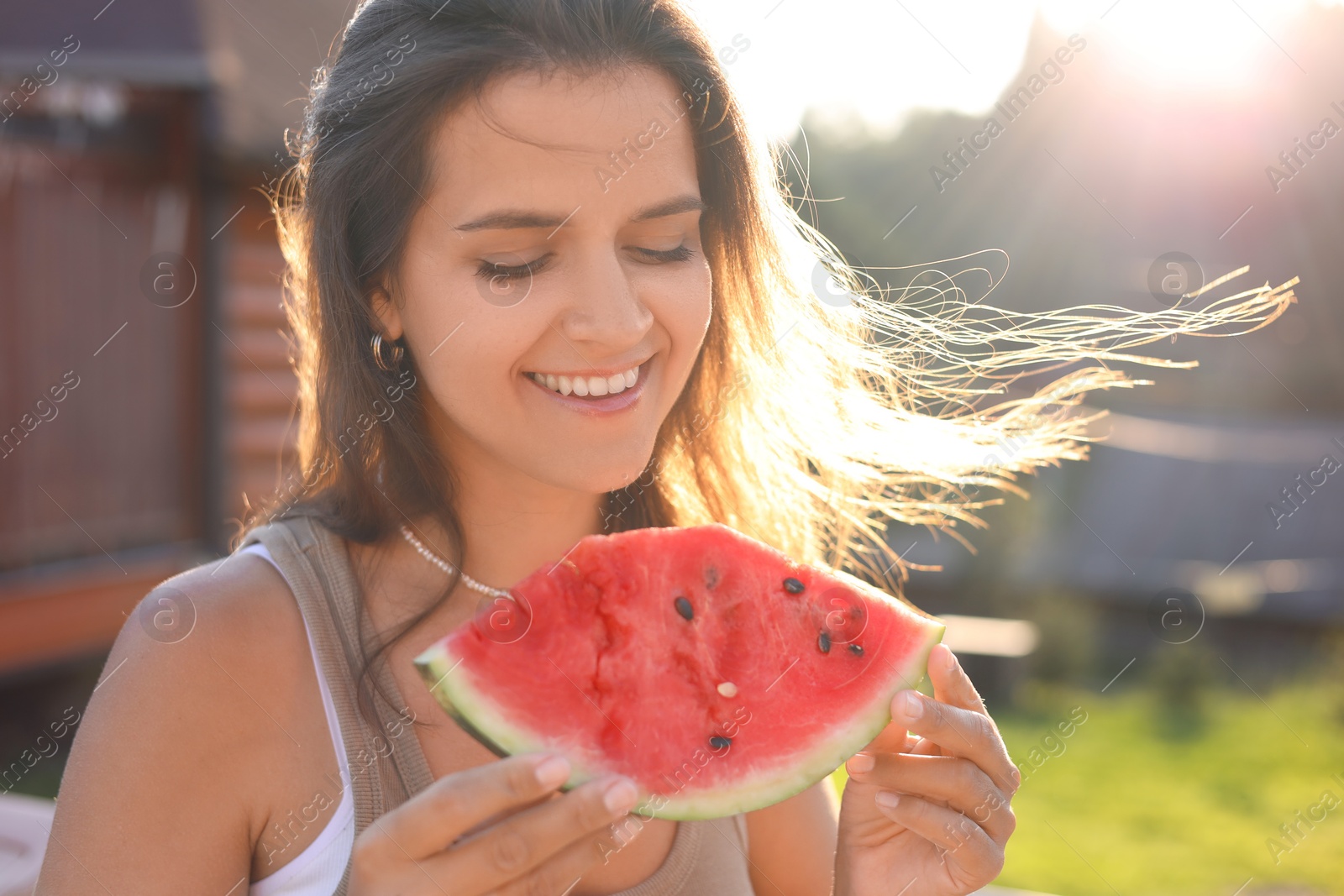 Photo of Happy woman with slice of juicy watermelon outdoors