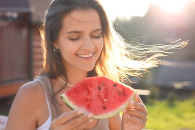 Photo of Happy woman with slice of juicy watermelon outdoors