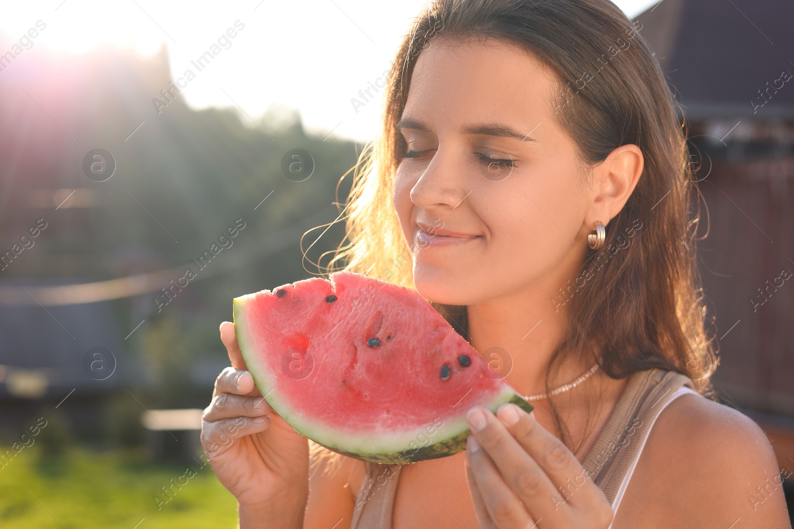 Photo of Happy woman with slice of juicy watermelon outdoors