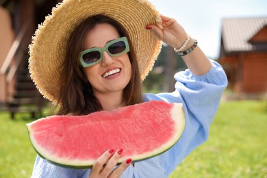 Photo of Happy woman with slice of juicy watermelon outdoors