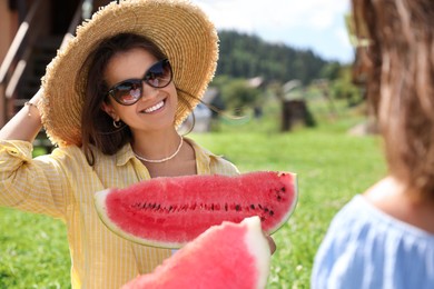 Women with slices of juicy watermelon outdoors