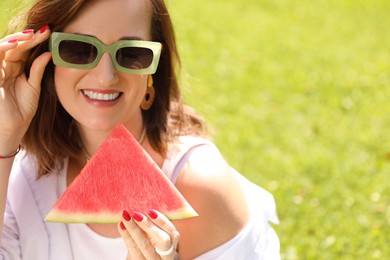 Photo of Happy woman with slice of juicy watermelon outdoors, space for text